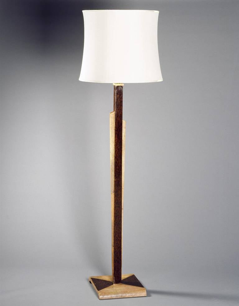 A rare Art Deco standard lamp in stained shagreen and palmwood taking the form of a column with a shagreen capital, flanked by asymmetric tapering shagreen panels. The whole is supported on a square platform enriched with triangular panels of