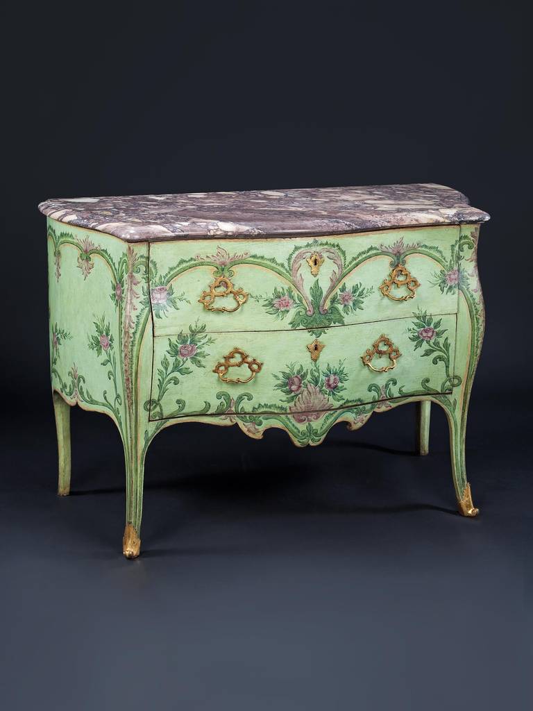 A rare pair of mid-18th century Neapolitan painted bombé commodes with marble tops, each having two drawers decorated 'sans traverse' with foliate scrolls and swags on a pale green background. The scroll legs terminating in gilt sabots. The handles