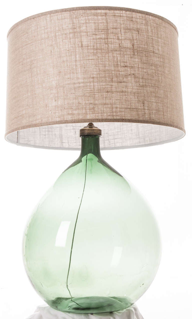 Large scale green glass blown wine keg now a lamp with a barrel burlap shade.