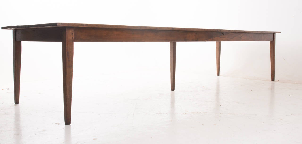 A handsome and large 12'+ French farm table in chestnut retains its beautiful, rich, original color and patina and has a fresh French polish, 1860s.