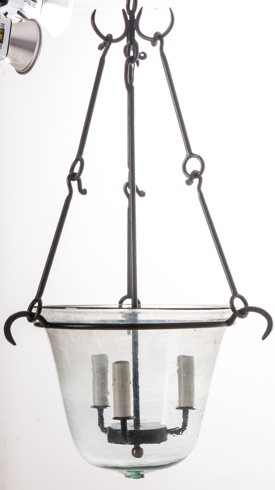 A custom designed hand made iron lantern holds an antique English glass cloche. A cloche was used in the garden to protect plants from frost and force their growth. Very few of these have survived, primarily because they were used outside in the