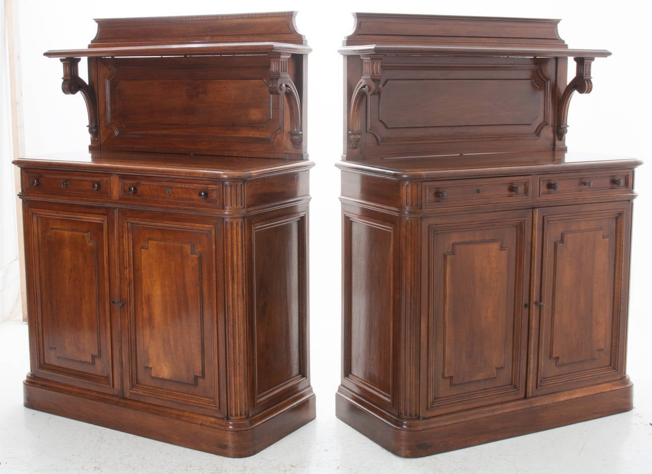 French 19th century pair of carved walnut buffets with paneled backsplash and an upper shelf above each buffet. This pair is exceptional with thoughtful carving and paneling, allowing you to enjoy the walnut patina. Each buffet has two locking