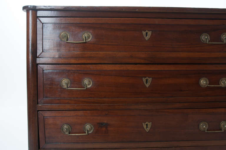 A gorgeous Louis XVI commode of walnut wood. Shaped wood top sits over the commodes rounded, pronounced corners, keeping a clean look all the way to it's feet. Three spacious drawers all dovetailed and in working condition make for abundant storage.