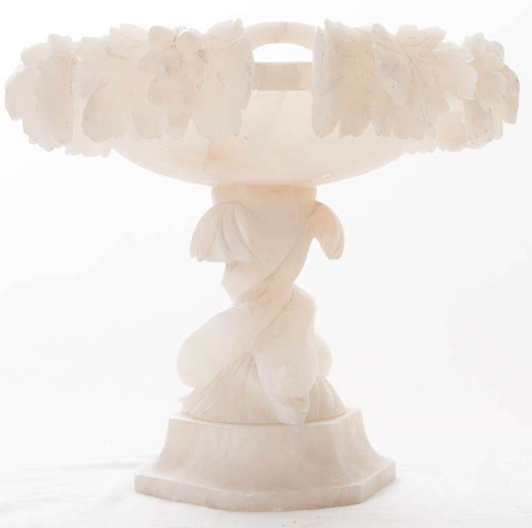 French white onyx footed compote with grapes and grape leaves with a pierced apron over twisting dolphins as the pedestal.