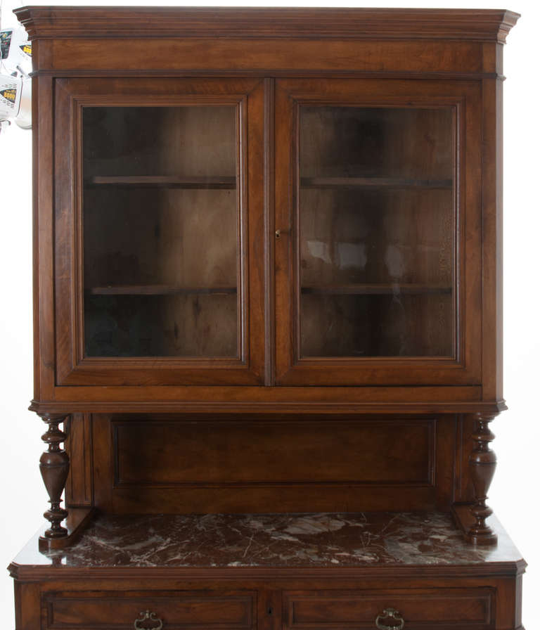 A handsome Louis Philippe buffet a deux corps! All solid walnut construction with stunning wood patina. The top part of this fine buffet has two large doors with old wavy glass, the interior is fitted with two adjustable shelves. Paneled back board
