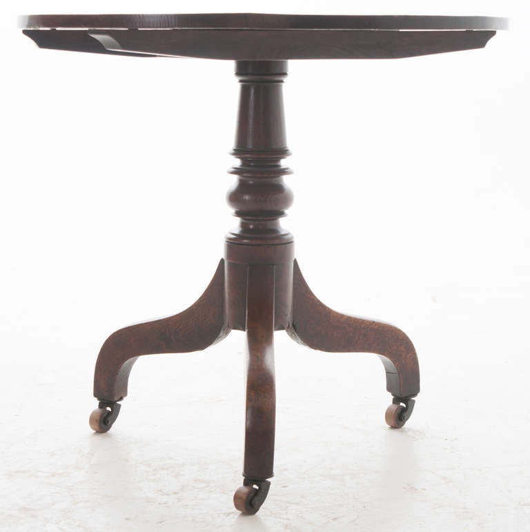 English Oak Round Tilt Top Table with pedestal base resting on 3 splayed legs with vignum vitae casters, C. 1820
Check our extensive website for more tables and antiques at firesideantiques.com