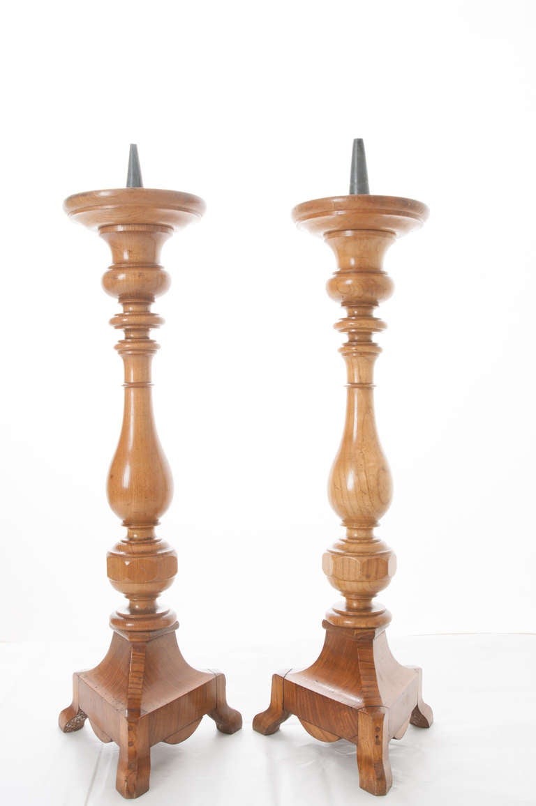 Wonderful pair of sculptural fruit wood turned candlesticks on tripod bases. Stunning color and patina with zinc candle spikes. 1880