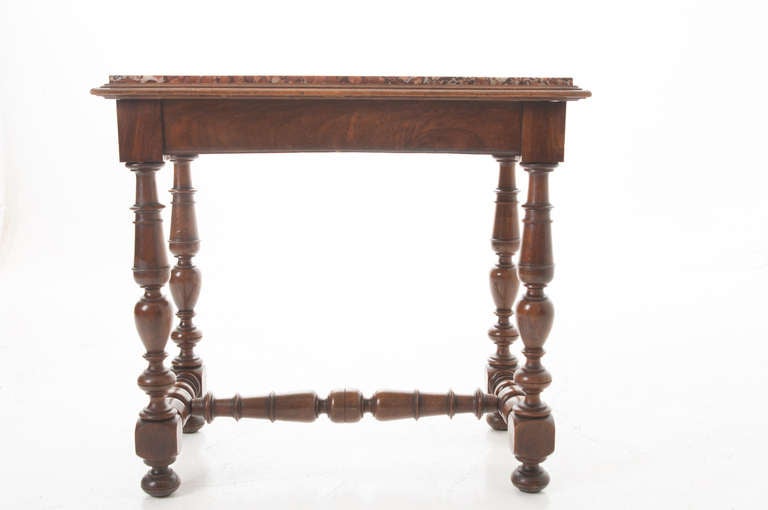 Darling French occasional table with inset marble top of tangerine, whites, blacks and rust coloring. Burled walnut base with four turned legs and an 'H' stretcher base on ball feet. 1840s