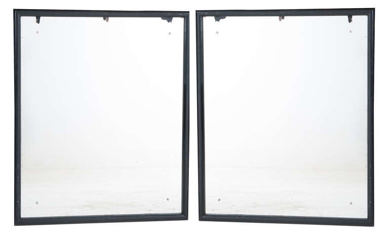 Wonderful pair of black frame bistro mirrors found in an old ice cream parlor which was built in the 1930's. Original mirror glass with light foxing, all held in with four silver studs. Both mirrors are symmetrical and can be hung horizontal or