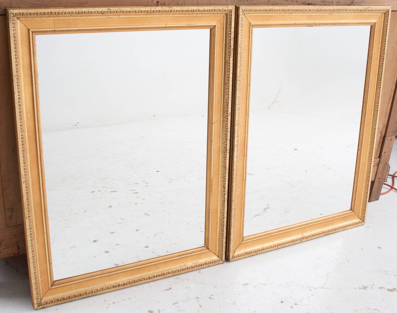 French pair of gold gilt symmetrical mirror frames from the later 1800s, both with new mirror glass.