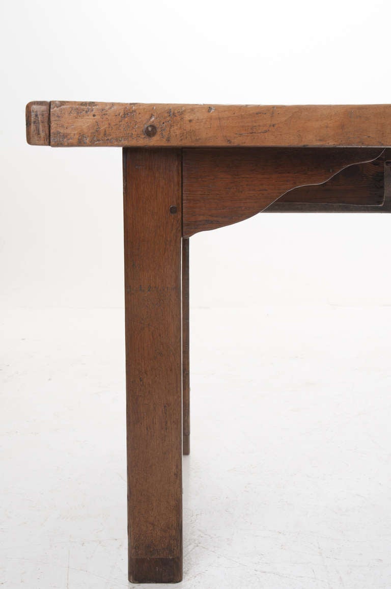A fine 18th Century French Farm table from the Breton region of France has impressive weight. Beech and pine wood's were used to make this thick top farm table with one drawer over thick block legs with scalloped brackets and worn stretcher