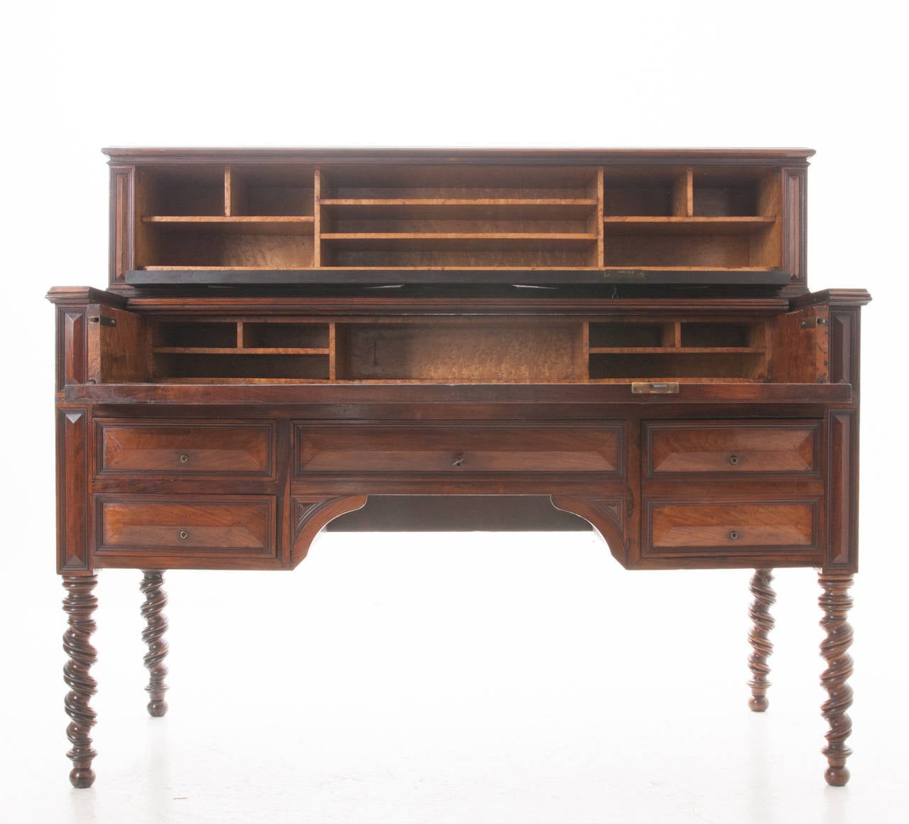 A handsome, impressive carved mahogany desk with gem-cut decorations and fitted bird's-eye maple interiors and original black leather writing surface. A very interesting key unlocks the top part of this fine desk, folding down to an interior fitted