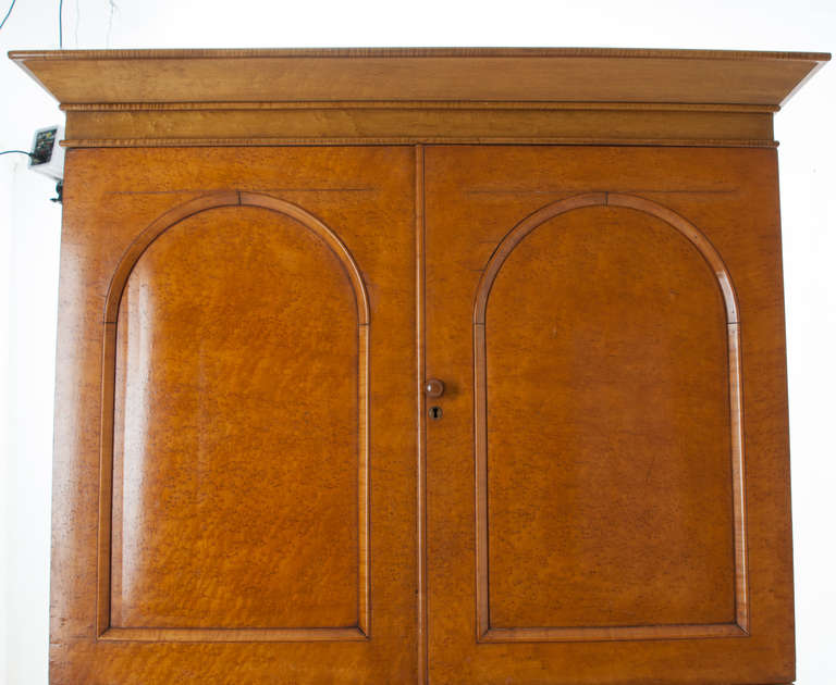 Bird's-eye maple linen press with three interior slides in the top. Five fitted drawers in the base with round wood knobs. Front of this linen press in bird's-eye maple and the sides are burled.