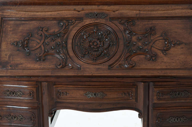 French Regence' style walnut Secretaire, circa early 1800s.

The moulded modified dome cornice above a conforming raised and recessed panel frieze embellished with scroll work, floral and foliate carvings above a glazed cabinet, with glazed sides,