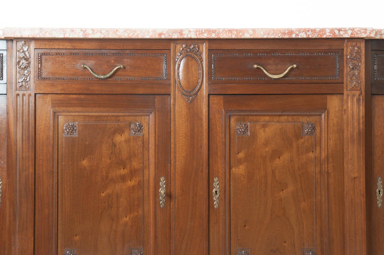 A gorgeous Louis XVI style demilune mahogany buffet with original shaped marble top. Four working drawers over four working and locking doors, all paneled and decorated with brass hardware. The whole over tapered and fluted feet.