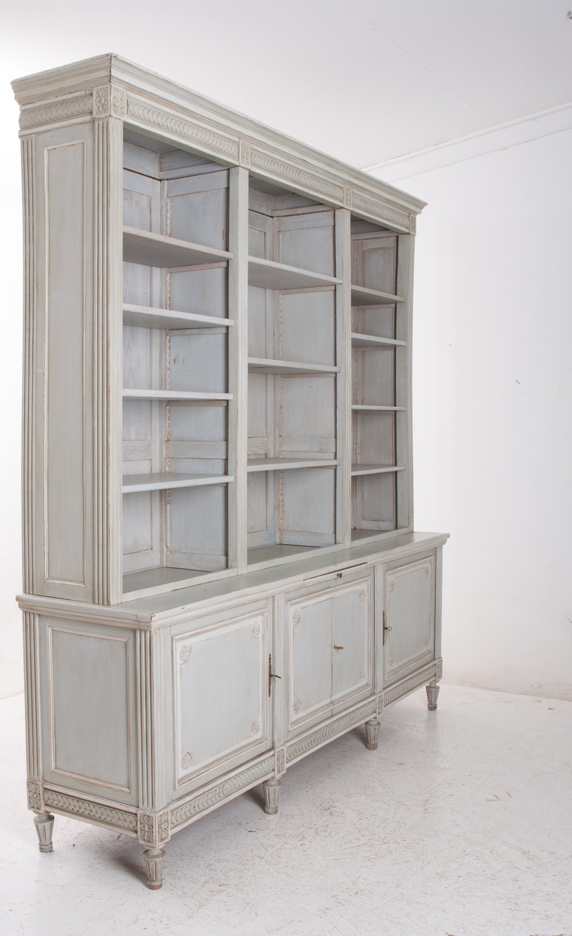 Made in France, this bookcase is made of old and new parts. The doors, carved motifs and panels were taken from a boiserie paneled interior and made into this fine bookcase. All painted to match the antique boiserie from the early 1800's.