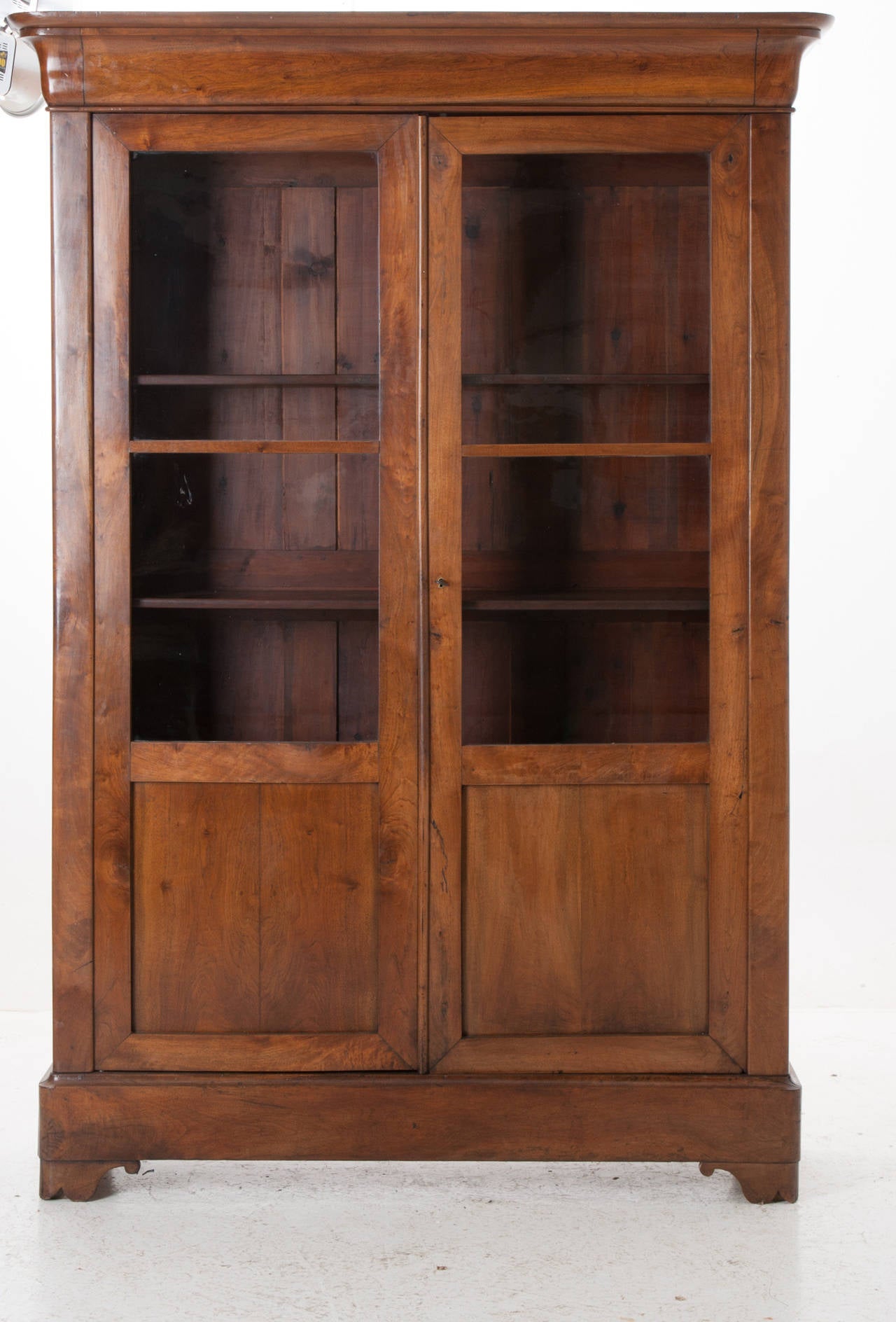 A stunning pair of Louis Philippe walnut bookcases in great condition. The pair are lovely together or apart in different locations of your home. The rich walnut coloring vary between each bookcase, one of which has its original wavy glass. The