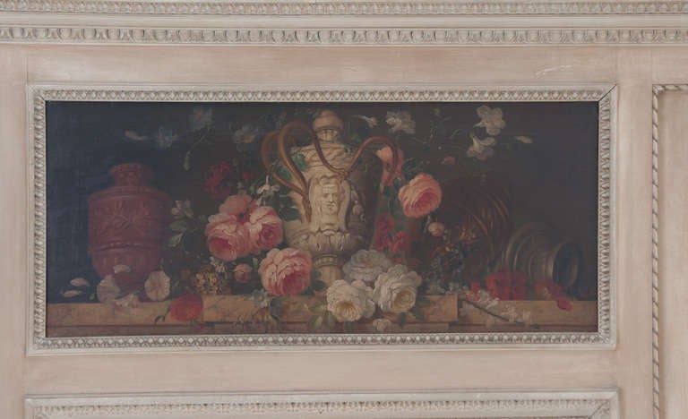 This fine trumeau starts with a finished crown, lotus leaf motif surrounds the top followed by the iconic egg and dart motif, the sides of the trumeau are paneled with ribbon molding. The floral painting also depicts urns and architectural elements,