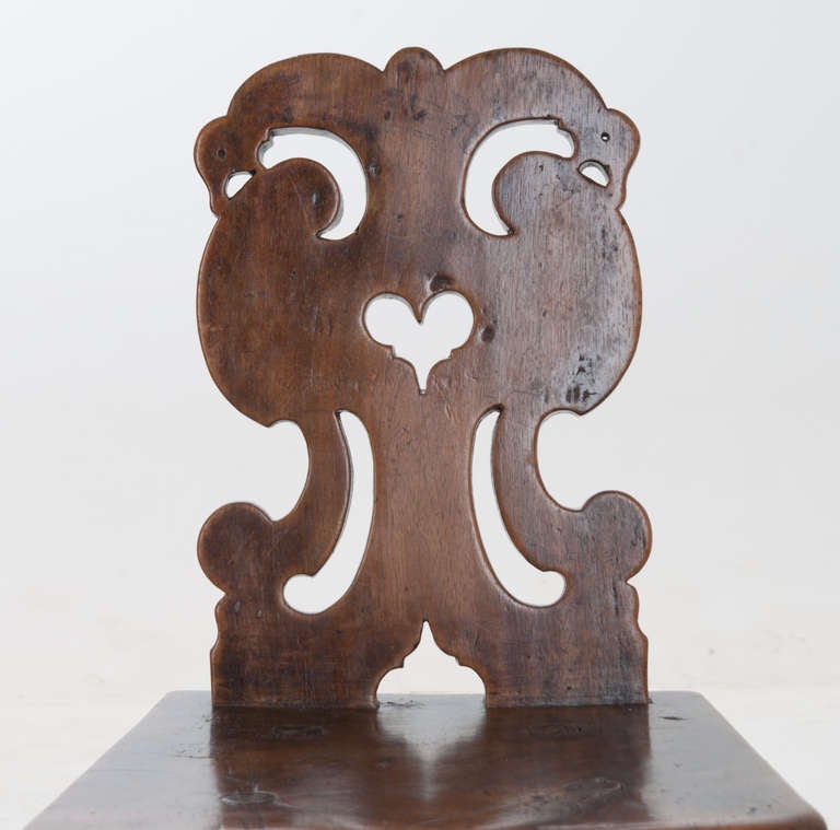 A primitive, completely hand-carved 18th century chair from Alsace, France. Ornately shaped and pierced back rest with heart shape and hand faceted legs and absolutely wonderful patina!!