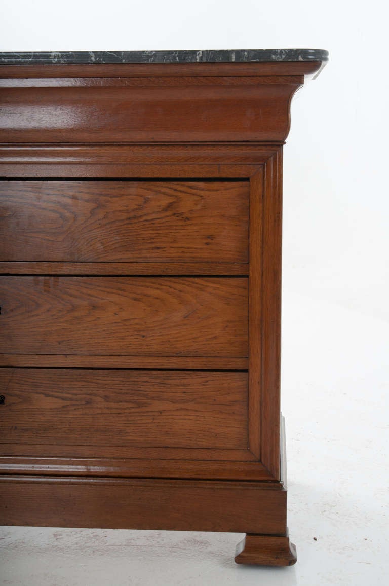 French Louis Philippe Oak four drawer commode with all locking drawers. Original marble top of gris de Ste. Anne with a bull nose curved front and sides sits over this Louis Philippe, minimal carved commode. 1860s or earlier.