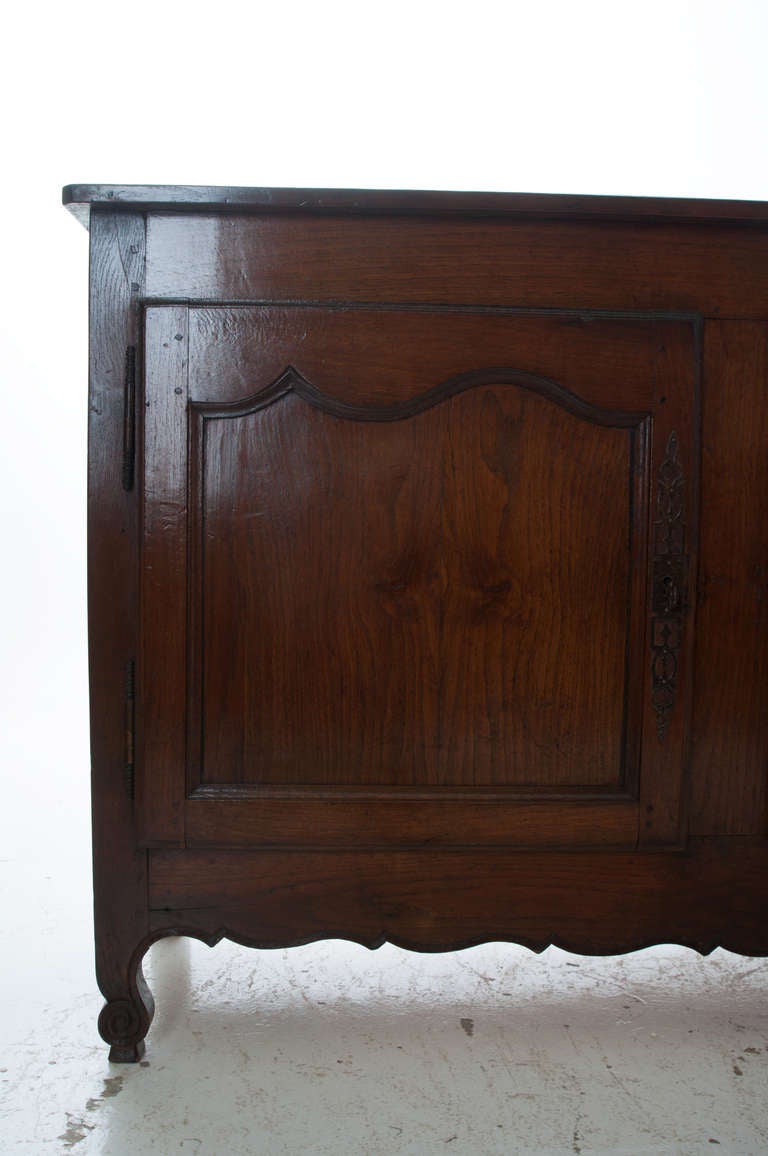 French dark oak Louis XV style primitive enfilade with a two board top of chamfered corners over a single drawer in center above three large paneled doors, impressive and long scalloped apron stretches between two scrolled feet. 1870s