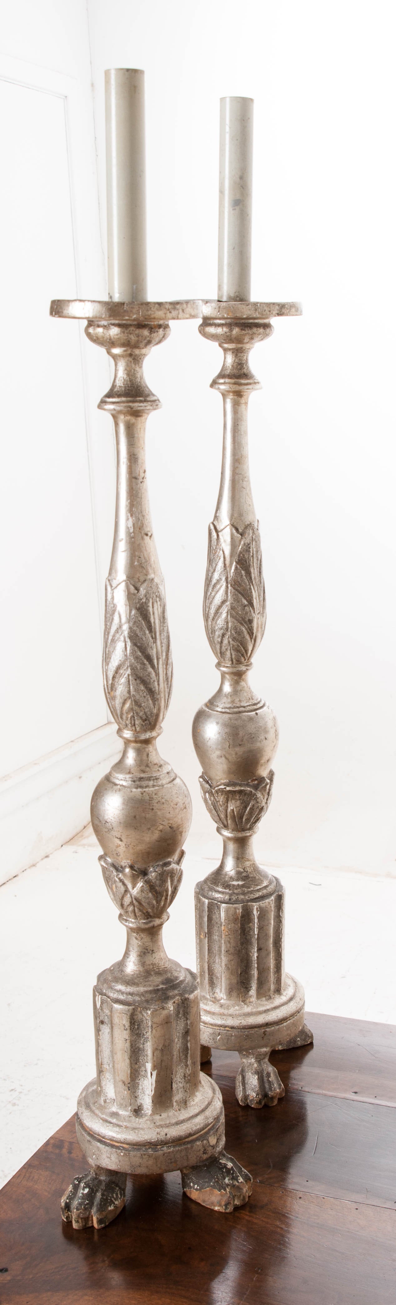 An impressive pair of tall hand-carved silver gilt candlesticks from France. See detailed pictures of the impressive detail and patina! An one point these candlesticks were wired for lamps, they have white candle covers hiding the wiring hardware,