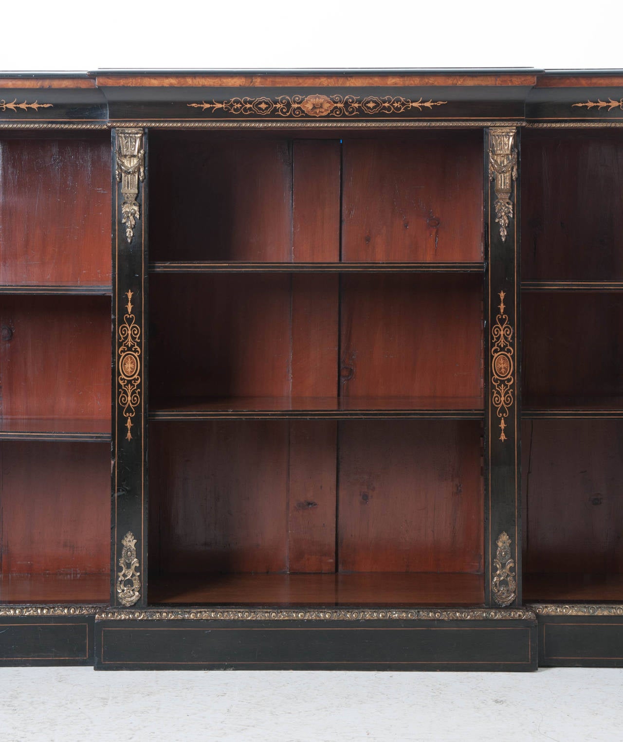 An extremely impressive ebony breakfront bookcase! This fine antique features exciting details of thick cast ormolu and inlay with satin wood and other fine burl woods. Be sure to see all the detail photos! 1810.