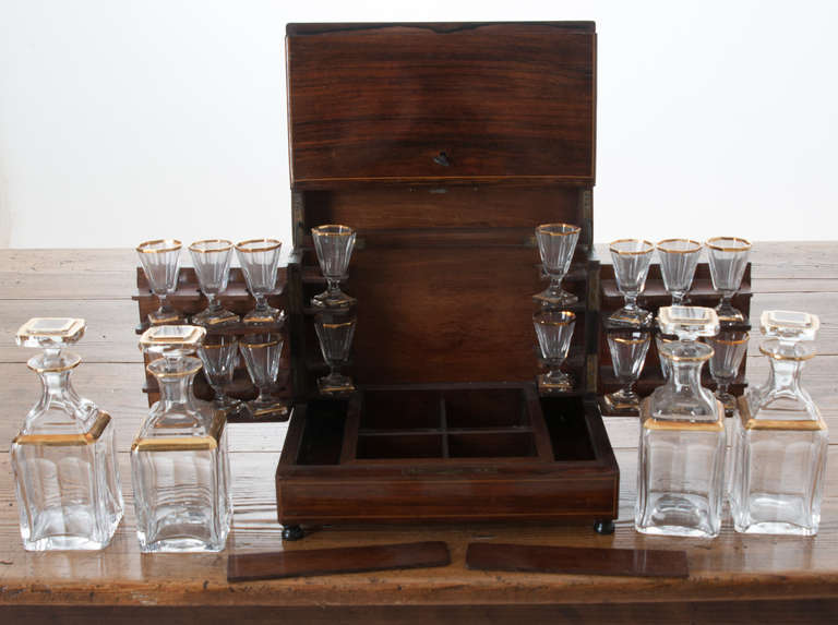 Beautifully inlaid floral and foliate marquetry on lid. Box opens to reveal a complete set of 16 small liquor glasses and four crystal decanters, reproduction glassware. Locking Tantalus has two secret compartments, dates from early 1900s.
Closed