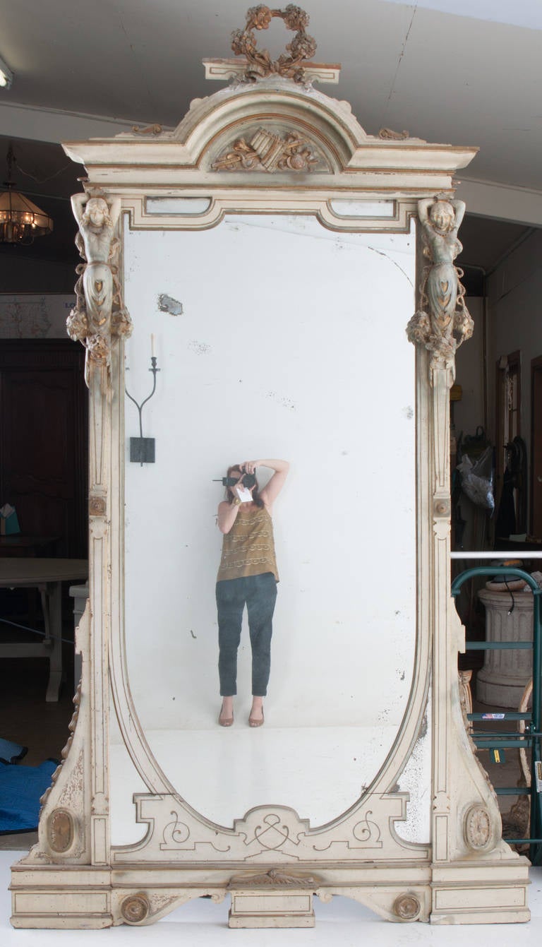 French Art Nouveau mirror from the early 1900s with poly chromed original finish. Mirror glass is original with some foxing and crystallization. Carved wood flanking female sea nymphs speak to Greek mythology and their seductive singing which lead