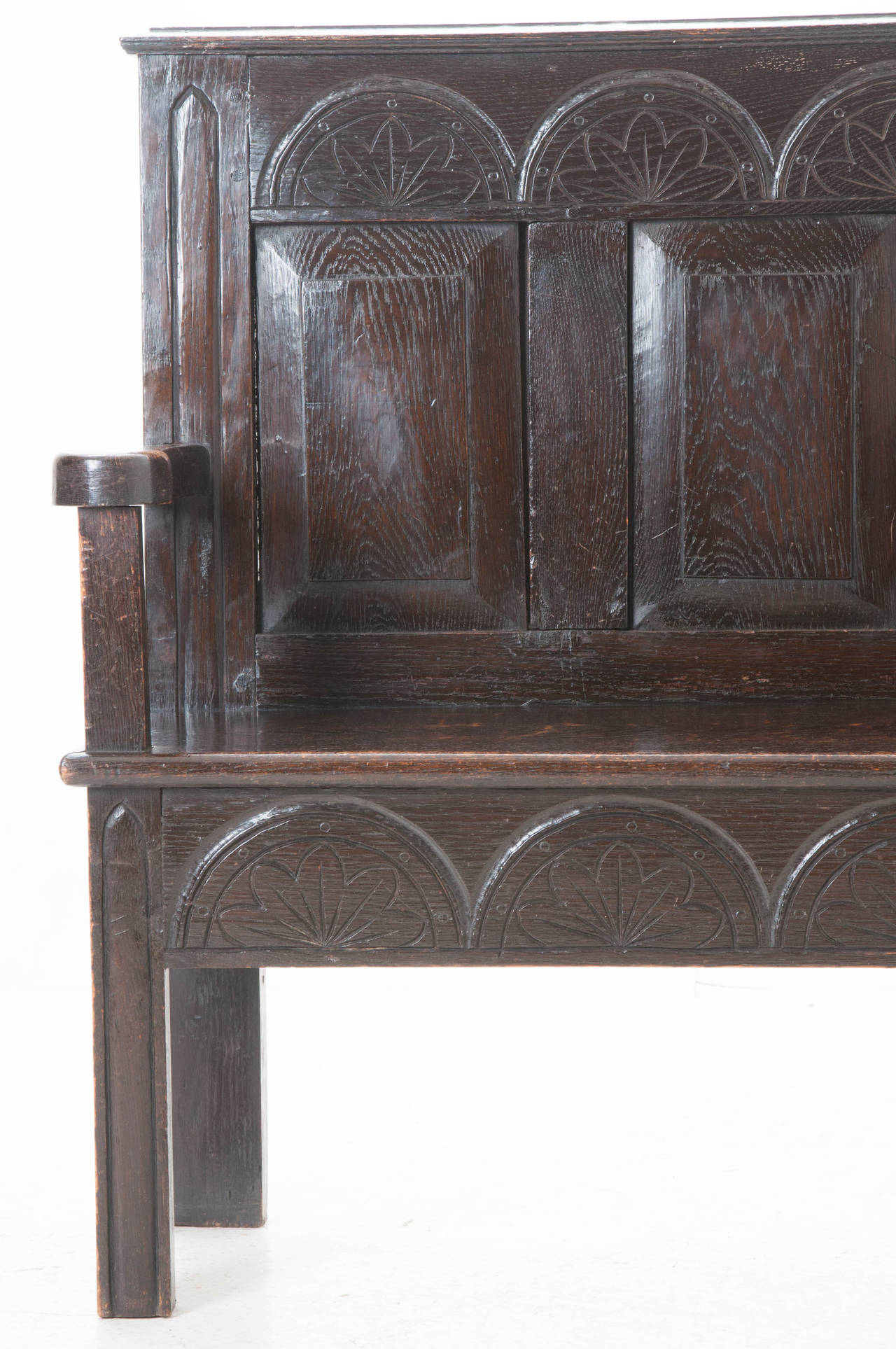 A fabulous hand carved dark oak settle from the late 1700s has stood the test of time! Settles were often used by the fireplace, with their high backs they could help keep the heat in. Be sure to view the detail photos!