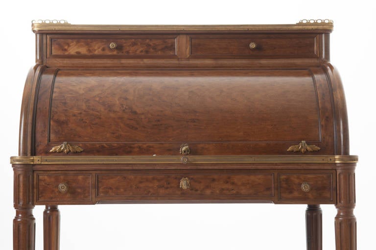 Elegant French Louis XVI lady's roll top desk of mahogany and Birdseye mahogany, a spectacular marble top has a pierced brass gallery with two drawers below. The D roll top features a fitted interior with three drawers and storage room, the writing