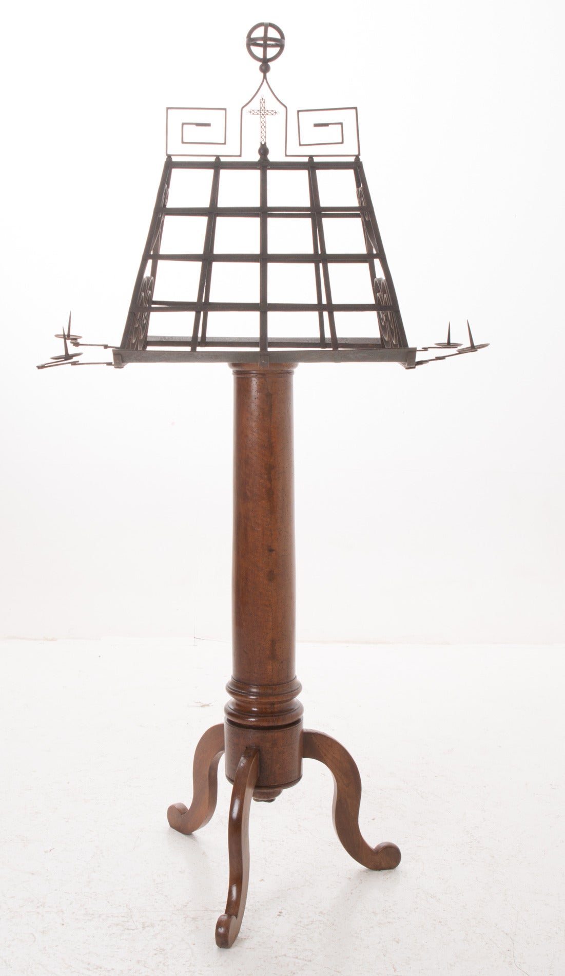 A top quality religious lectern from a church from which a bible was read from. This is a stunning forged iron top has scrolls, Greek keys and crosses with four extending candleholders! The turned mahogany base is a healthy size and ends with three