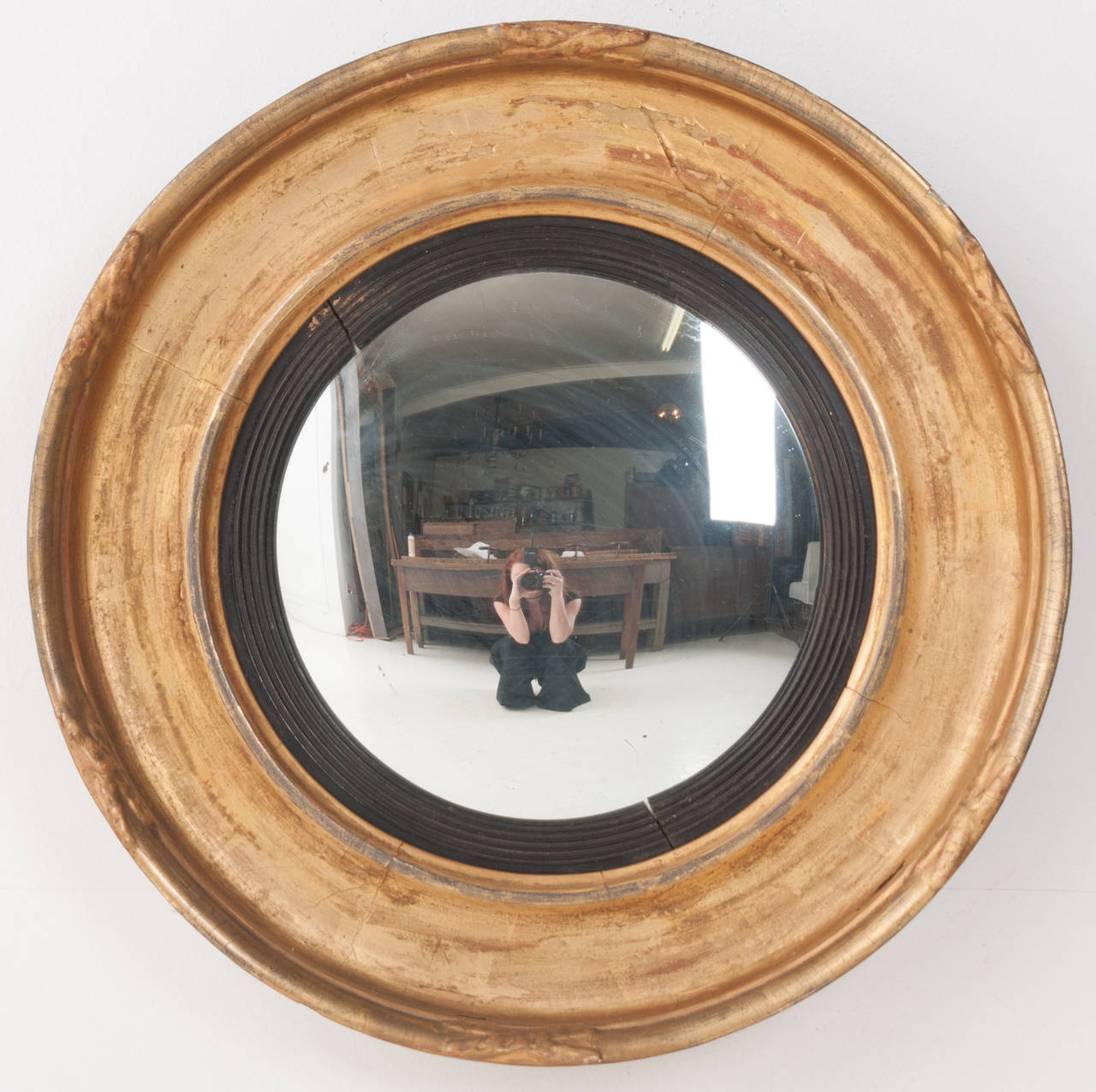 English round carved gold gilt mirror frame with ebonized detail and convex mirror. 1810