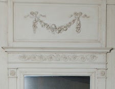 French painted wall paneling of Boiserie from Rouen, France with original marble fireplace and trumeau. Wall paneling has three well carved floral swags and bows across the top, two half size glass doors or either side of the fireplace with double