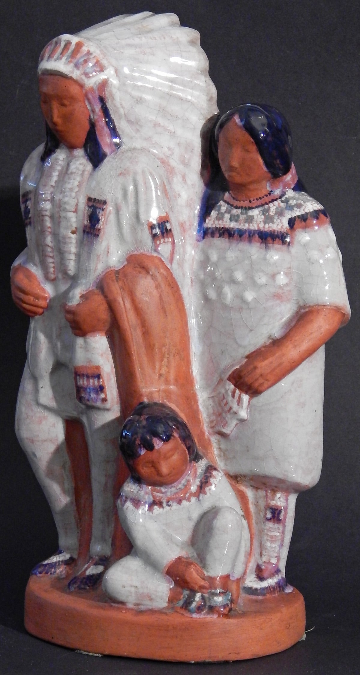 This remarkable ceramic sculpture, probably the best work of Elisabeth Andersen Seaver, one of the famous Cleveland School ceramicists -- depicts an Indian chief with full feather headdress, with his wife and child, all in snowy-white dress. Seaver