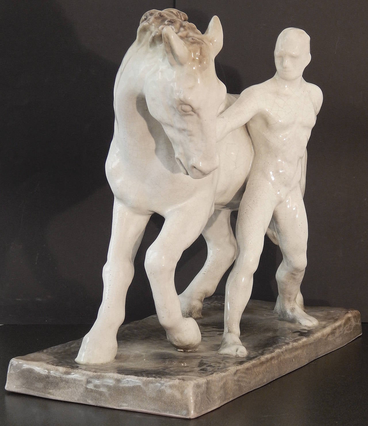 The large and rare Majolica group consisting of a nude male figure walking a horse was sculpted by Else Bach for the famous Karlsruhe ceramic works in the 1920s-1930s. Bach is best known as an animalier, although she also liked to pair nude male