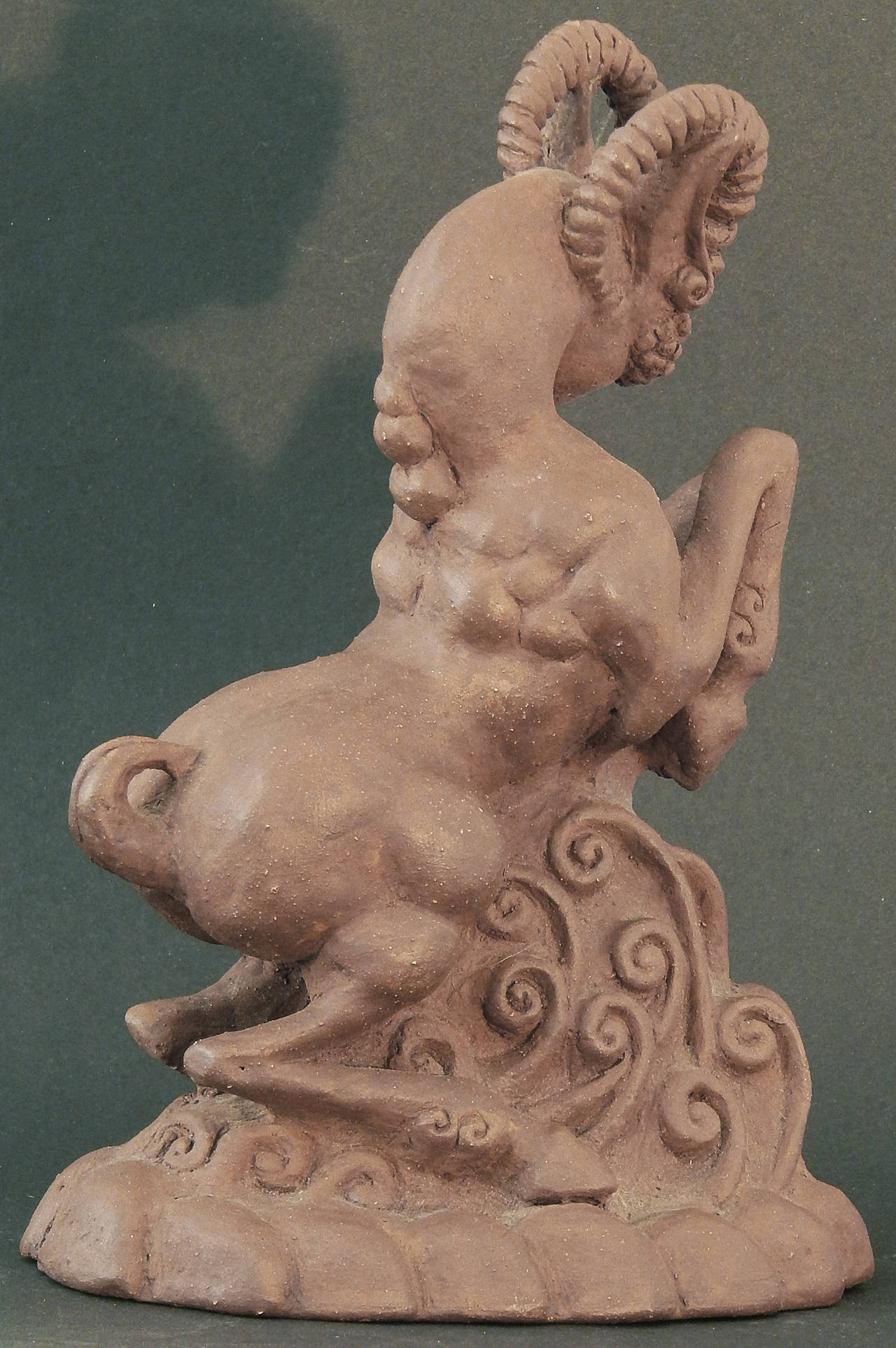 This unique Art Deco sculpture -- carved, not molded -- depicts a highly-stylized goat figure with the ears of a satyr rearing up over a mound of Art Deco tendrils. The mythological feeling of the goat is reminiscent of the animals that romped to