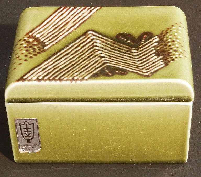Brilliantly glazed in spring green, ivory and dark brown, and decorated with highly abstract zigzag and foliate motifs, this highly rare covered box is a superb example of American Art Deco design.  It was produced by Kenton Hills near Cincinnati,