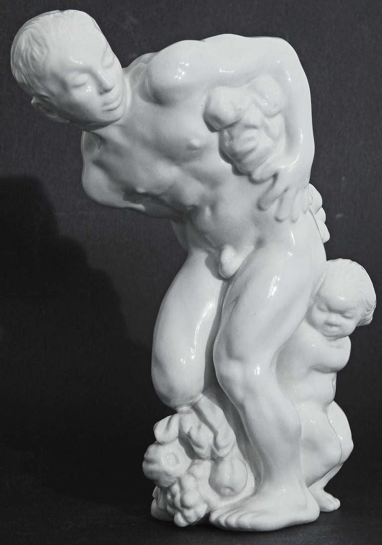 Sculpted by Kai Nielsen, Denmark's leading figurative sculptor in the first decades of the 20th century, this rare porcelain sculpture depicts a nude male figure holding a heavy fruit garland, with a small child behind one leg.  No doubt an