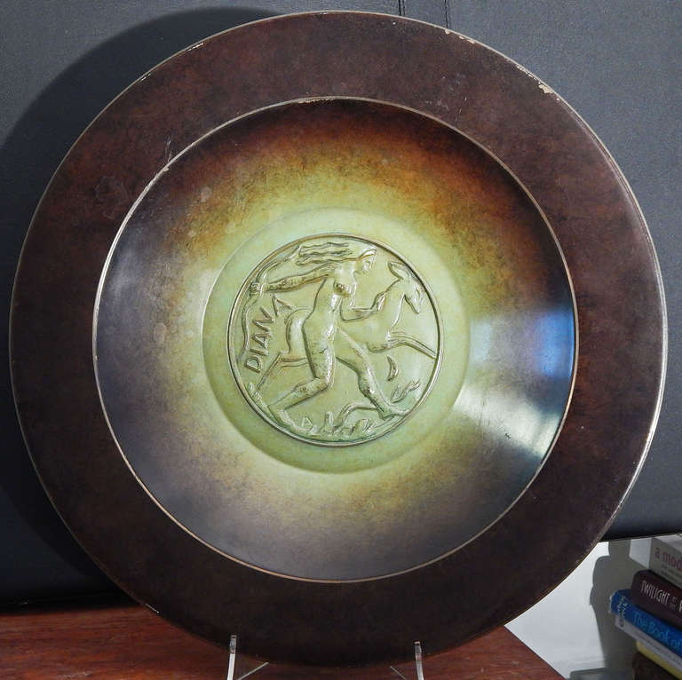 Splendidamente scolpita e realizzata in bronzo dalla rinomata fonderia di Ystad, in Svezia, questa ciotola di grandi dimensioni raffigura la dea Diana, con l'arco in mano, che corre in avanti con i capelli che volano e la mano sul collo di un cervo