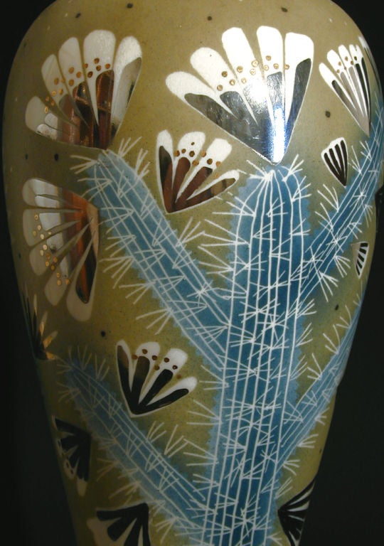 Magnifiquement émaillé dans des tons de vert mousse et de bleu-vert par Waylande Gregory, ce vase rare et de grande taille représente un cactus en fleur, dont le feuillage est rehaussé d'argent métallique. Prodigieux et infatigable, Gregory a