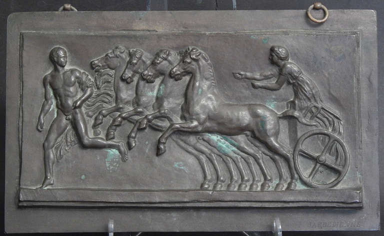 Magnifiquement modelée, coulée et finie, cette plaque en haut-relief représentant un homme nu suivi d'un char à quatre chevaux conduit par une femme vêtue a été produite par la célèbre fonderie Barbedienne à Paris.  Ferdinand Barbedienne a fondé sa