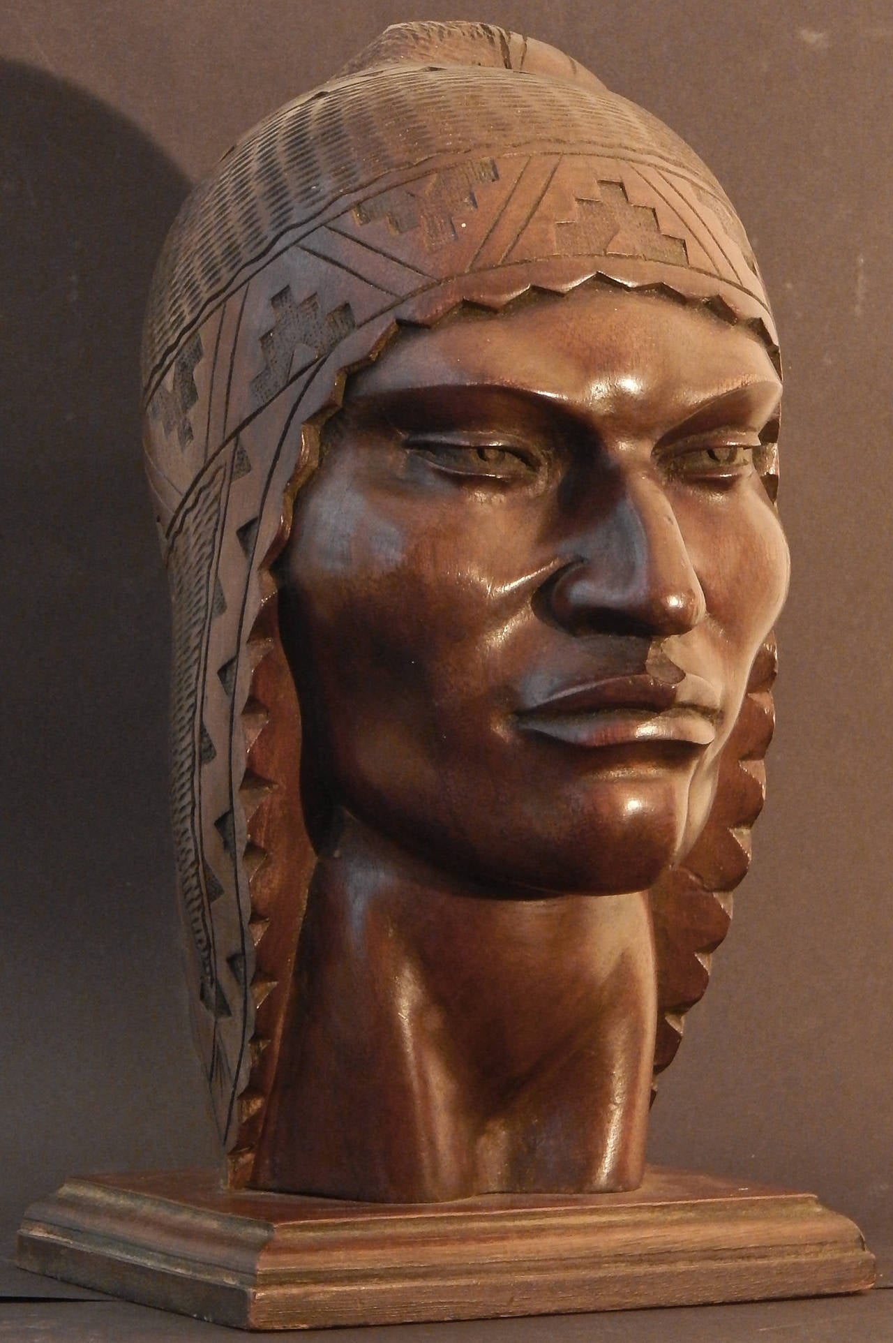 Superbly carved and visually striking, this life-size depiction of a Peruvian man in a traditional knitted headdress is a superb example of stylized Art Deco sculpture, as well as the fascination that American artists had in native cultures and