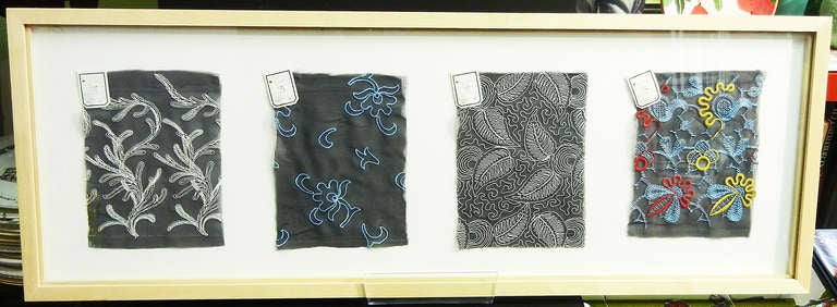 Bellamente diseñado y ejecutado, este conjunto de cuatro muestras de tela están bordadas con hilos plateados, azules, rojos y amarillos, y datan de la Alemania de los años veinte.  Conservan sus etiquetas de patrón originales, y están enmarcadas