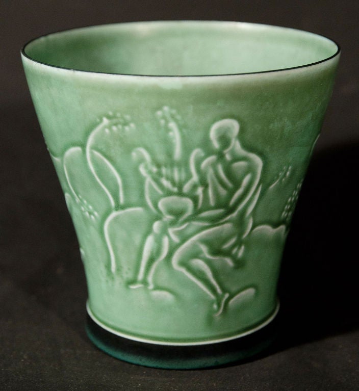 This very rare Art Deco vase -- the first we have ever seen -- shows a semi-nude Greek God holding a lyre, surrounded by exotic plants and birds, all executed in a fine bas relief and glazed in a gorgeous jade green color.  The piece was produced by