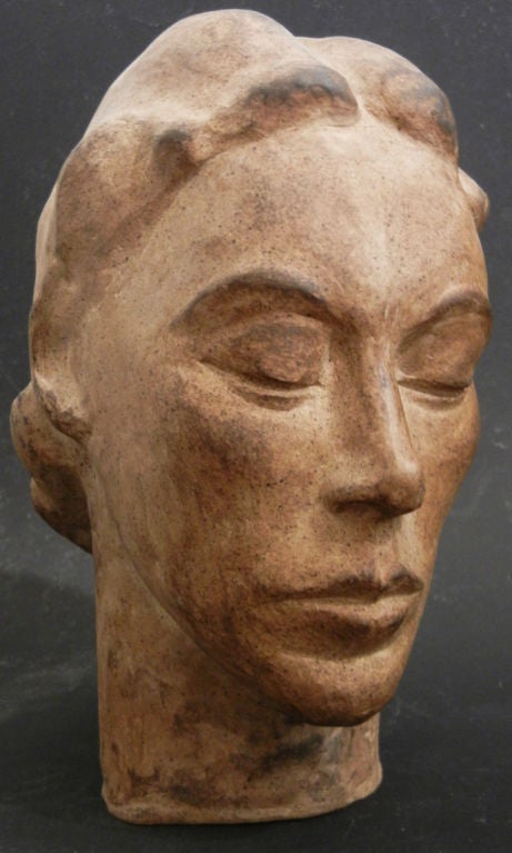 Diese Terrakotta-Skulptur ist ein klassisches Beispiel für das Art Déco. Sie zeigt eine schöne Frau mit hohen Wangenknochen und zurückgekämmtem Haar, die ihr ein ruhiges, friedliches Aussehen verleiht. Die Terrakotta hat eine reiche Patina von