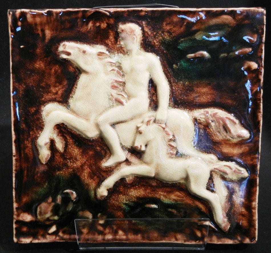 This rare majolica tile panel, produced by the important Karlsruhe manufactory in southwest Germany, depicts a male nude on horseback, accompanied by a pony of the same hue. The factory was established in 1901 by Grand Duke Friedrich I, and was