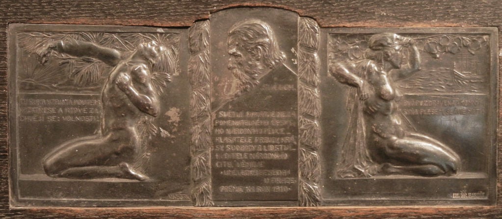 Set into an ebonized oak panel, this fine bas relief panel features two nudes -- male and female -- flanking a bust memorializing a Czech leader.  The panel was cast by the Bartak foundry in Prague.