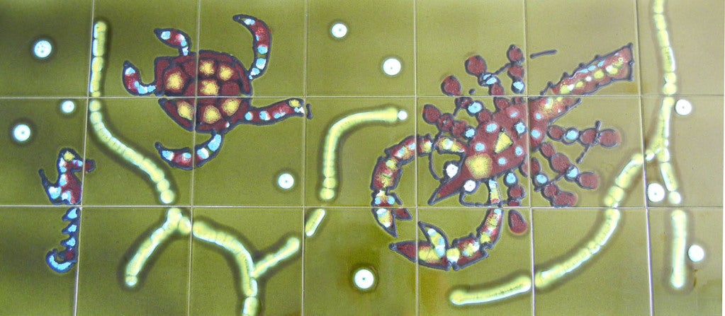 Signée Aoni, cette rare table basse en carrelage représente un homard et une tortue s'ébattant parmi des brins d'algues ondulants, dans de superbes tons d'olive, de vin profond et de canari.  Les glaçures brillantes se combinent magnifiquement avec