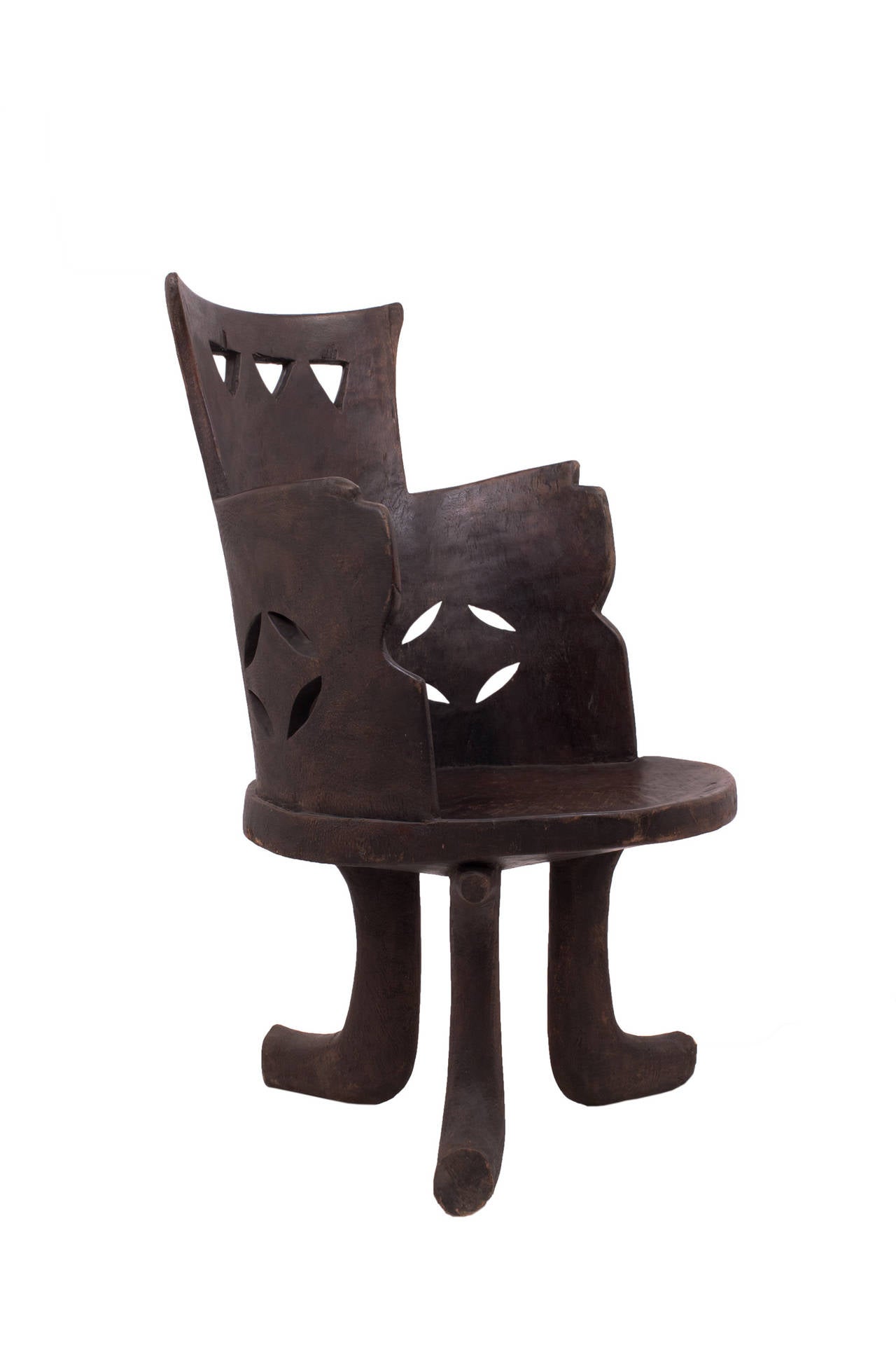 Carved from a single piece of wood, this chair is like a functional piece of sculpture. The curve in the seat of the chair provides support, the three legs are fully balancing. These items are never produced en masse and are exceedingly hard to